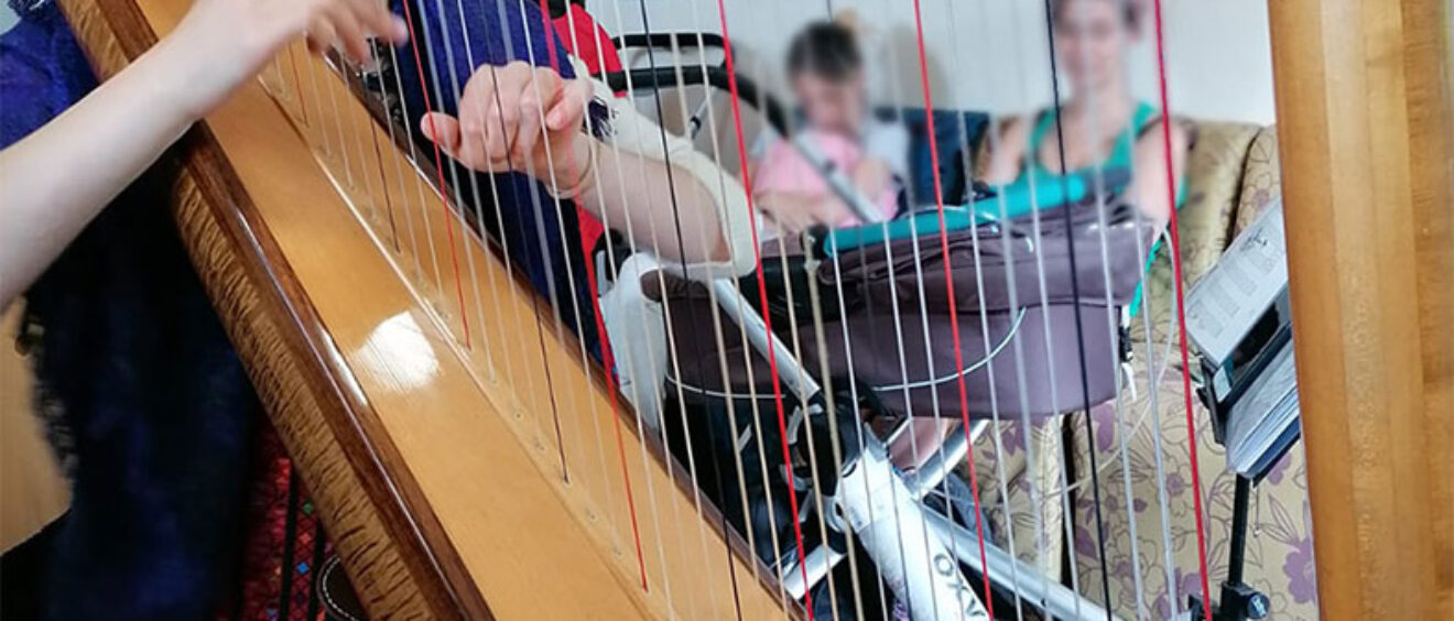 Emmy playing harp to parents and babies