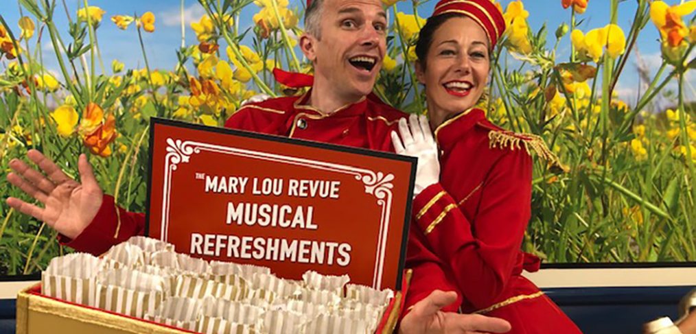 Performers dressed in red as ushers with tray of 'musical refreshments'