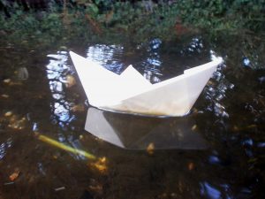origami boat floating on water
