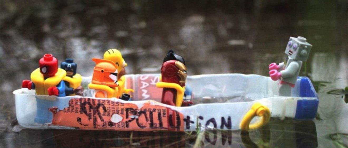 Photo of lego figures with life jackets on plastic raft (cut up plastic bottle) on water