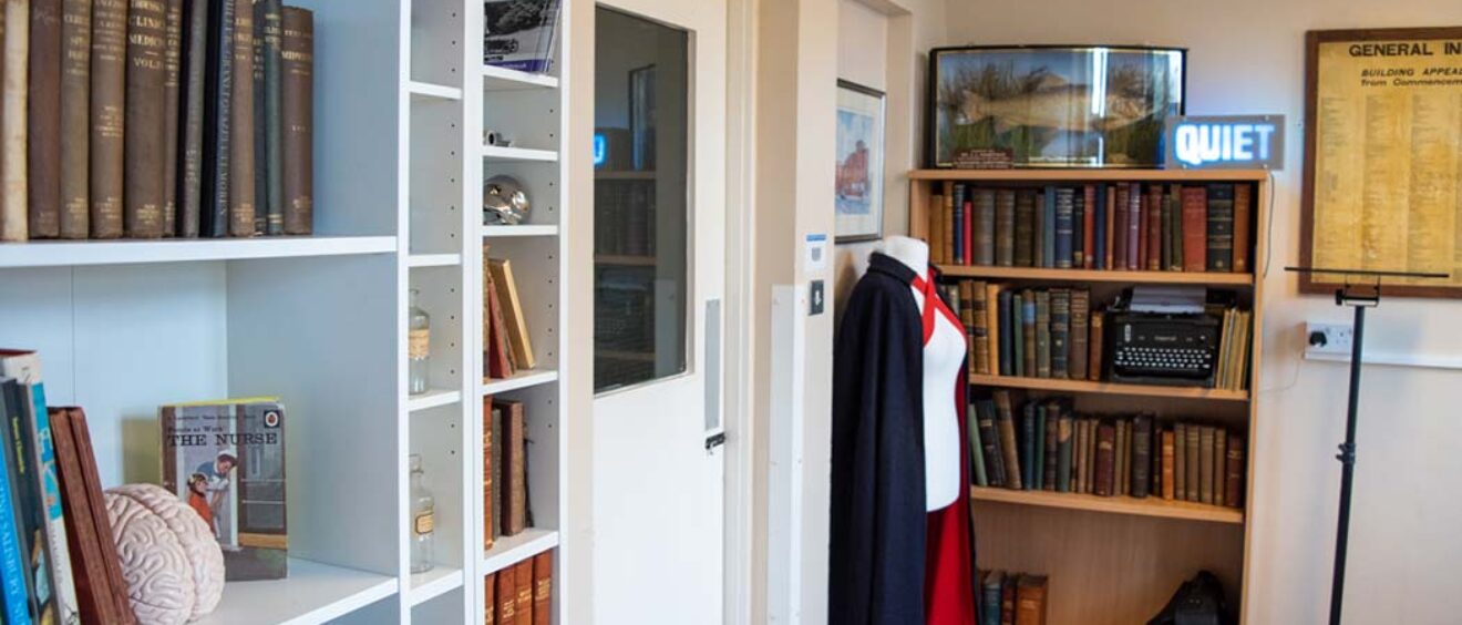 historical books and artefacts including nurses cape on dummy in culture club history space