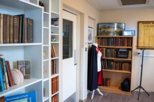 historical books and artefacts including nurses cape on dummy in culture club history space