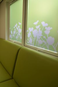 Window film design with flower silhouette on green background