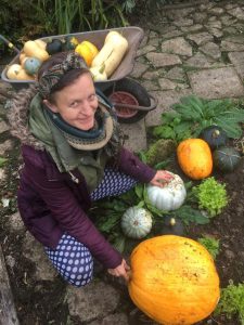 Hannah with a wide variety of colourful squashes she has grown