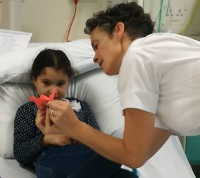 Stephanie shows child patient origami bird
