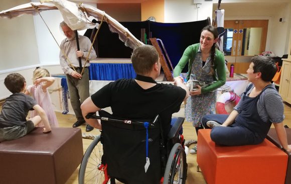 Performer showing Albatross puppet to adult in wheelchair
