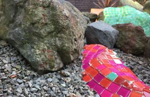 mosaic applied to rock in garden
