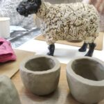 Photograph showing sheep sculpture and two pinch pots