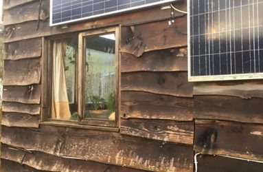 two solar panels mounted on side of wood panelled structure
