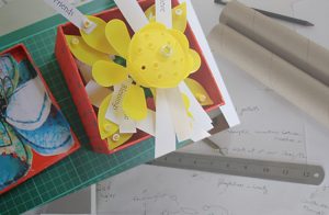 Jottings, pencil, paper and example memory box with words attached to model flower petals