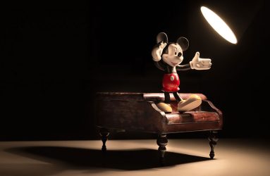 spotlight shining on Mickey Mouse figurine sat on model piano
