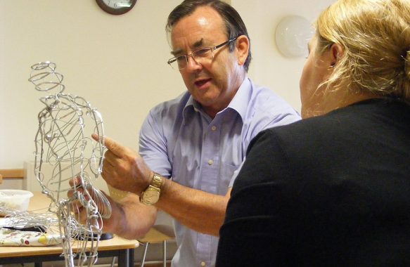 Martin working on wire figure with staff member