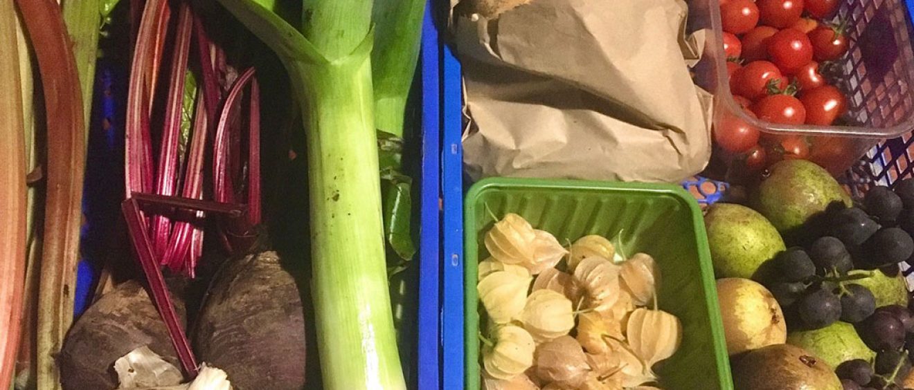 crate filled with leeks, beetroot, tomato, physalis, grapes, pears, rhubarb and potatoes