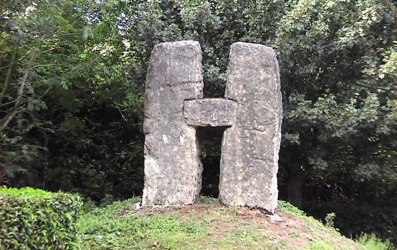 Stone blocks in form of letter H on grass bank
